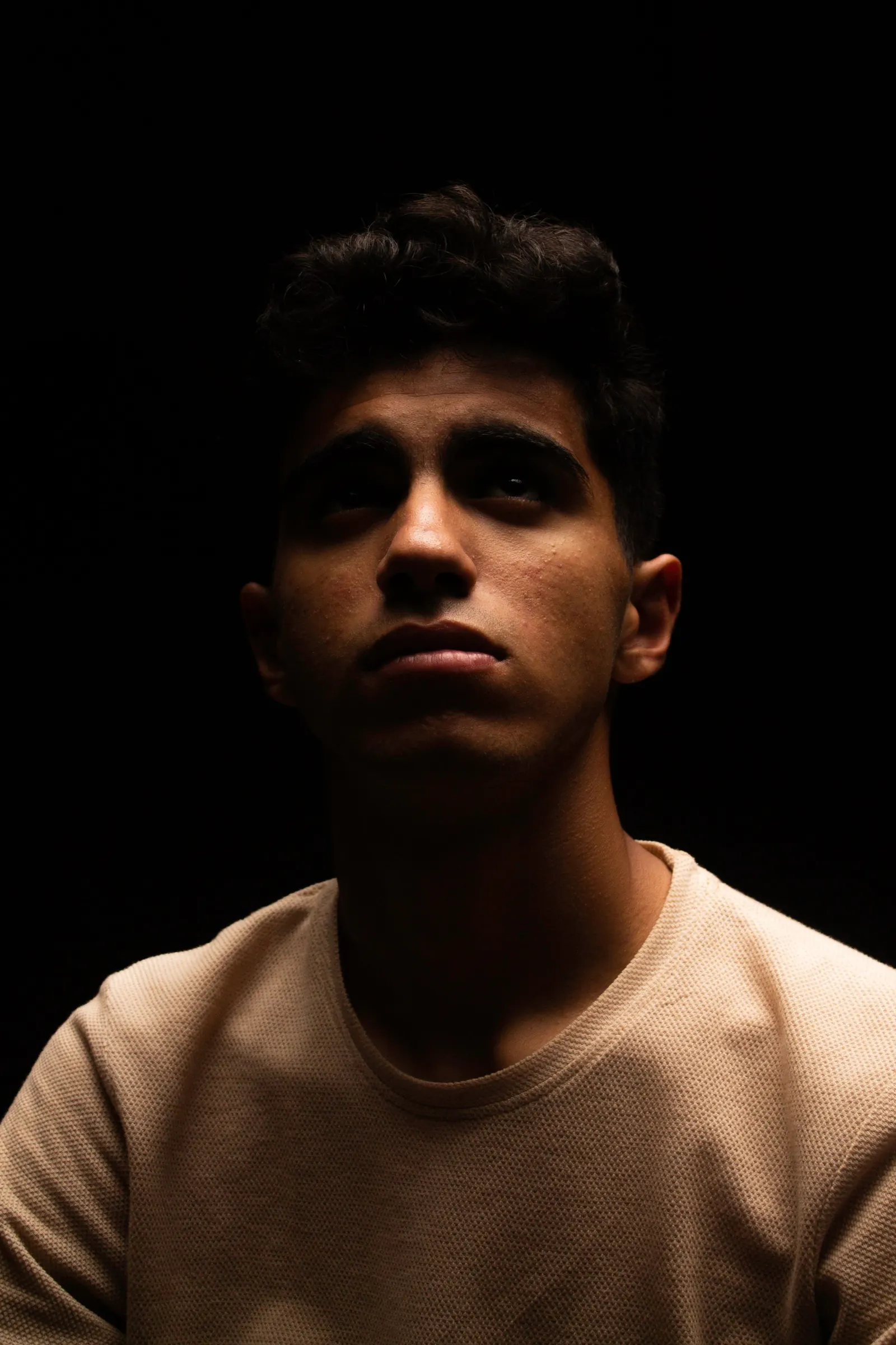 A young man photographed in a dark studio