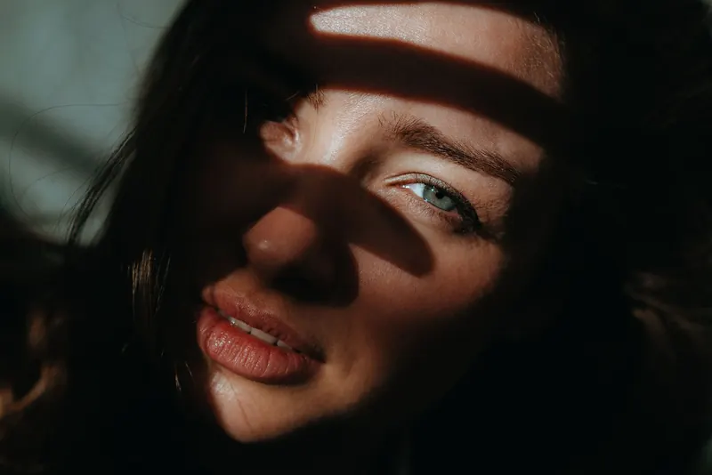 A woman's face with a soft shadow falling across it